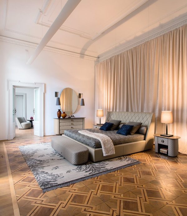 Elegant bed with a plush headboard featuring clean, vertical lines and a luxurious, tufted design for added comfort and style