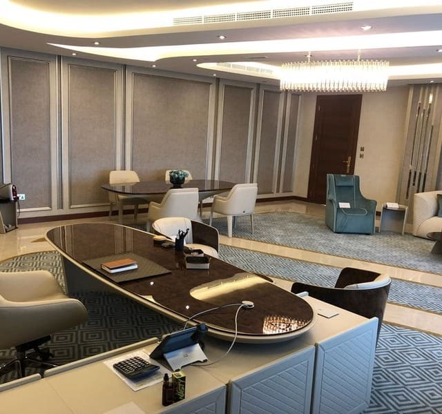 A CEO office with luxury desk, chairs, a meeting table and a sofa area