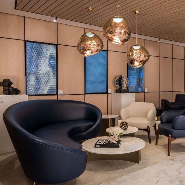 A reception waiting area with a curved sofa and two armchairs
