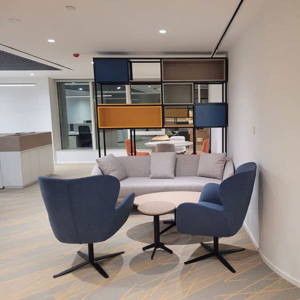 An office waiting area with a long sofa and 2 ratatable chairs