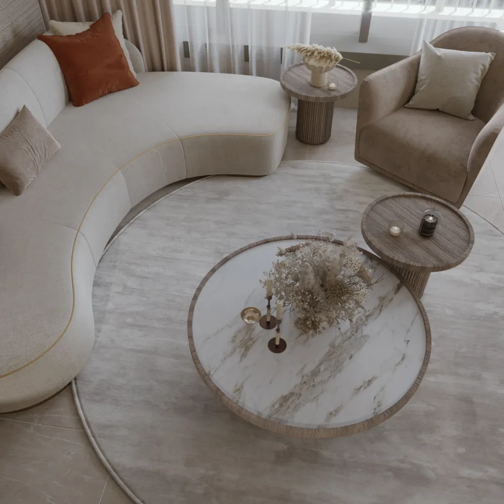 A modern sitting interior design with a curved sofa, luxury nested coffee tables and a round soft rug